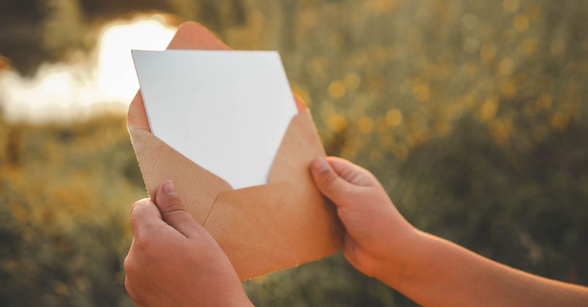 Person holding open envelope